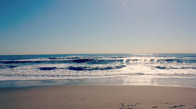 Image alt-text: sunlight reflects off the ocean as it meets the shore
Title: Virginia Beach
